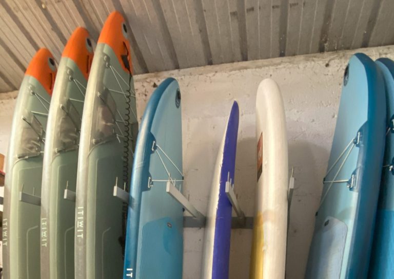 Stand Up Paddling Verschiedene Stand Up Paddling-Boards stehen hochkant an einer Wand.
